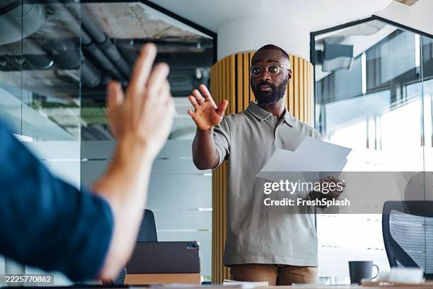 confident businessman presenting in a modern office meeting environment - impact stock pictures, royalty-free photos & images