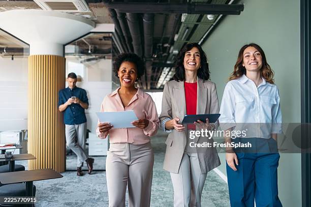 lächelnde geschäftsleute, die in einer modernen büroumgebung zusammenarbeiten - organigramm stock-fotos und bilder