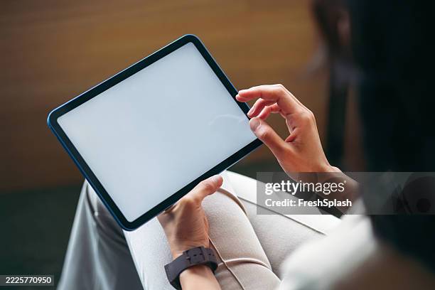 person using a digital tablet with white screen in a relaxed setting - digital tablet stock pictures, royalty-free photos & images