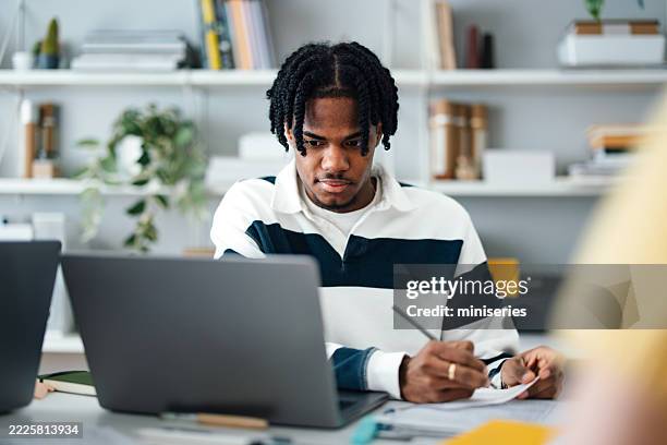 focused student engaged in studying with resources in modern study space - knowledge is power stock pictures, royalty-free photos & images