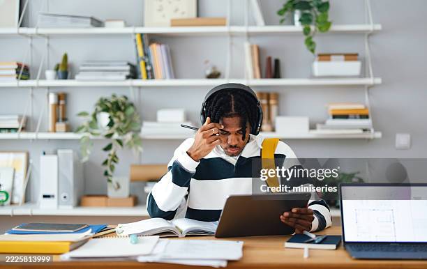 student studying in a modern library working on tablet - rethinking stock pictures, royalty-free photos & images