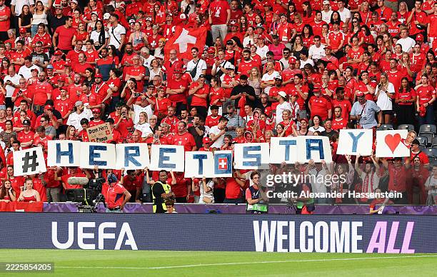 Fans of Switzerland display a TIFO reading "#heretostay" prior to the UEFA Women's EURO 2025 Quarter-Final match between Spain v Switzerland at...