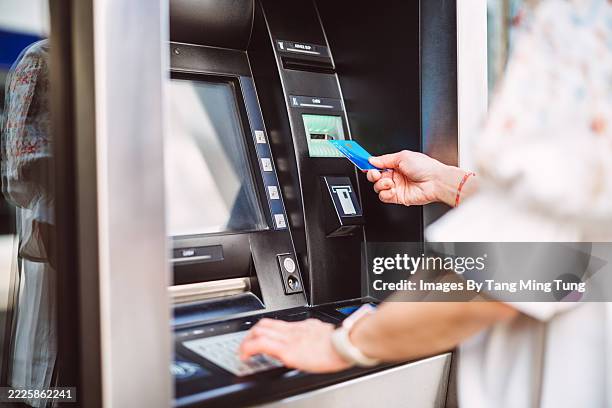 woman using atm for cash withdrawal with credit card - atm stock pictures, royalty-free photos & images