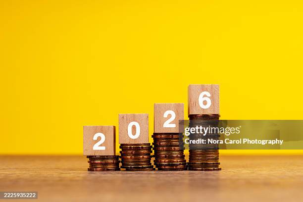 2026 on wood block on top of stack of coins - home finances stock pictures, royalty-free photos & images