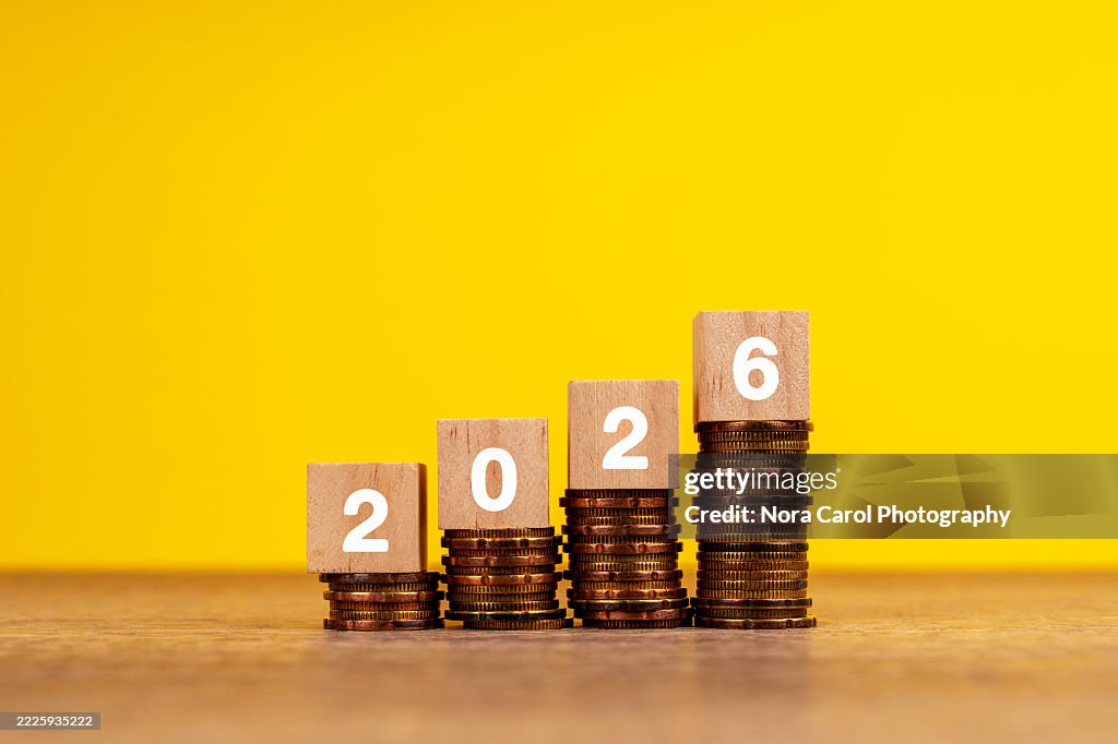 2026 on Wood Block on Top of Stack of Coins