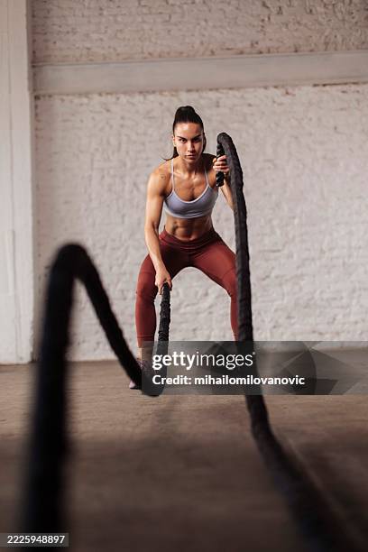 sportive déterminée s’entraînant avec des cordes de combat - entraînement croisé photos et images de collection