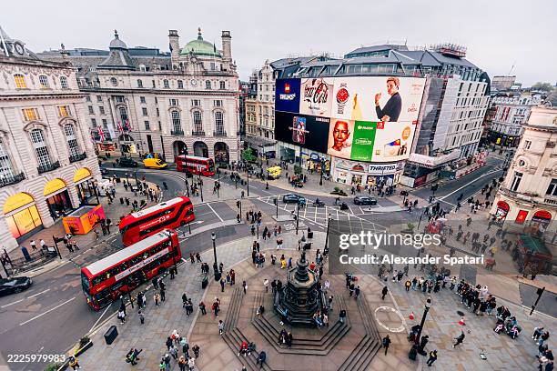 wide angle view of piccadilly circus with led screens ads and red double-decker buses, london, england, uk - piccadilly circus city of westminster stockfoto's en -beelden