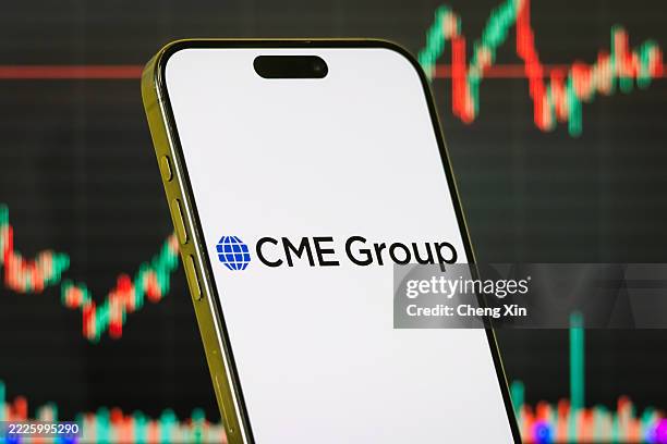 In this photo illustration, a smartphone displays the logo of CME Group Inc. , the world's largest financial derivatives exchange operator, in front...