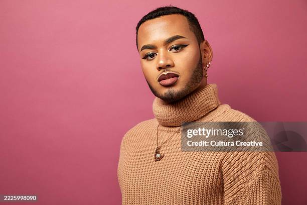 studio portrait of queer man against purple background - queer fotografías e imágenes de stock