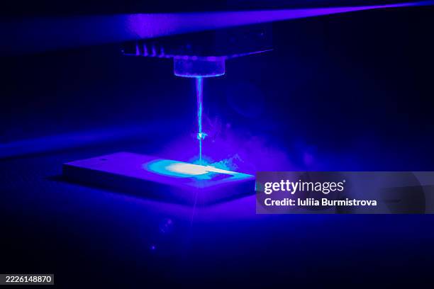 close-up of blue laser engraving material in a dark environment - laser engraving stock pictures, royalty-free photos & images