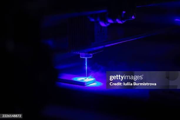 lose-up of a blue laser engraving machine in operation - laser engraving stock pictures, royalty-free photos & images