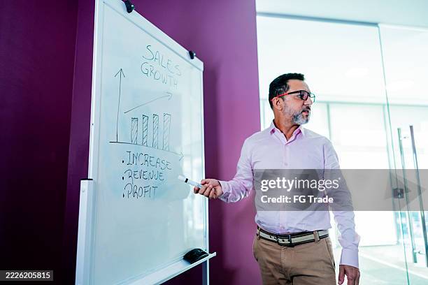 mature businessman talking during meeting at office - english language stock pictures, royalty-free photos & images
