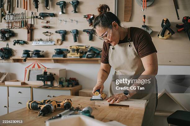 asian chinese mature woman polishing wood panel in woodshop workshop - half timbered stock pictures, royalty-free photos & images