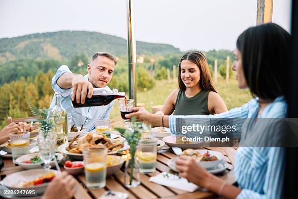 friends enjoying outdoor meal near scenic nature - outdoor dining stock pictures, royalty-free photos & images