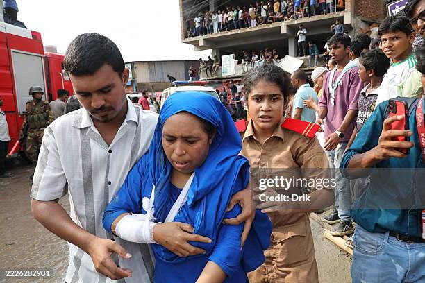 Victim is taken to a safe place after being provided with primary treatment from the accident site after a Bangladesh Air Force F7 aircraft crashed...
