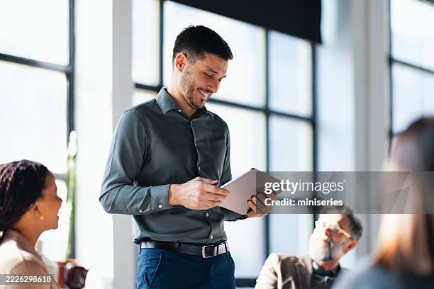 confident professional presenting ideas during a business meeting in modern office - styrelse bildbanksfoton och bilder