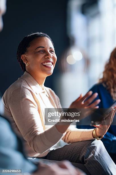 smiling professional engaged in a collaborative work discussion in a bright office - participant stock pictures, royalty-free photos & images