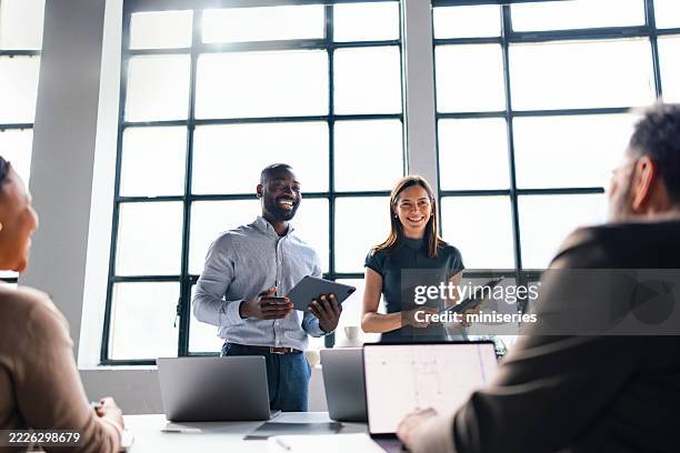 une équipe d’affaires professionnelle discute d’idées dans un environnement de bureau moderne - réunion du personnel photos et images de collection