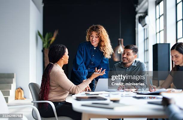 team engaging in a collaborative business meeting at a modern office - employee engagement stock pictures, royalty-free photos & images