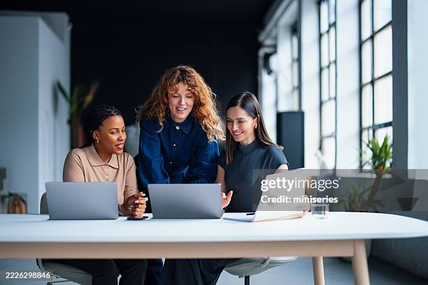 geschäftsfrauen, die in einer modernen büroumgebung an laptops zusammenarbeiten - bildschirmpräsentation stock-fotos und bilder