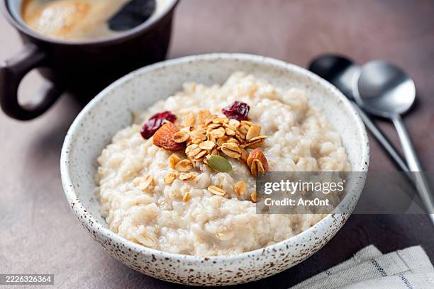 oatmeal porridge with granola topping - harina de avena fotografías e imágenes de stock