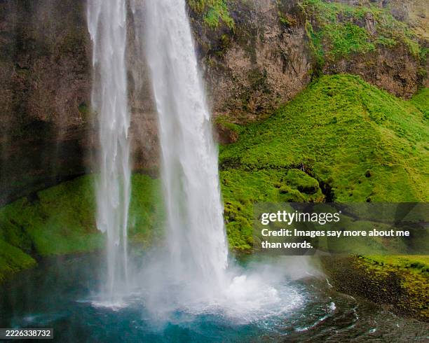 seljalandsfoss view from very close with water splashing forming a blue lagoon - lagon photos et images de collection