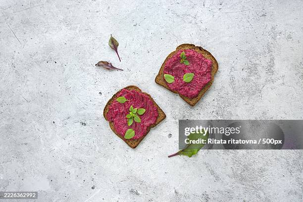 beetroot spread generously served on grain toast with fresh herbs - beetroot dip stock pictures, royalty-free photos & images