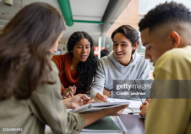 happy group of students studying together at the library - studying stock pictures, royalty-free photos & images