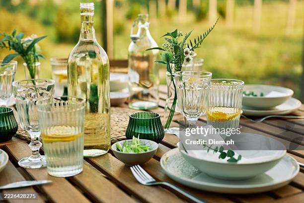 elegant outdoor dining table with greenery accents - gedekte tafel stockfoto's en -beelden