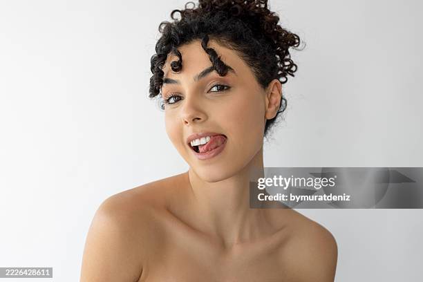 beautiful woman sticking her tongue out - mensentong stockfoto's en -beelden