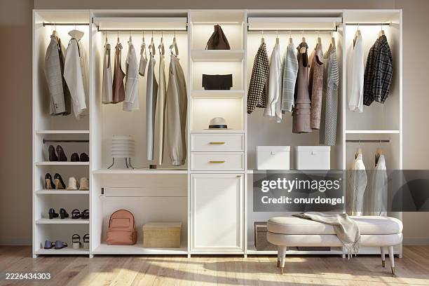 front view of wardrobe with shoes, bags and hanging clothes. modern dressing room - kast stockfoto's en -beelden
