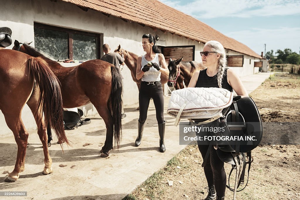 Group of riders getting ready for a horse ride
