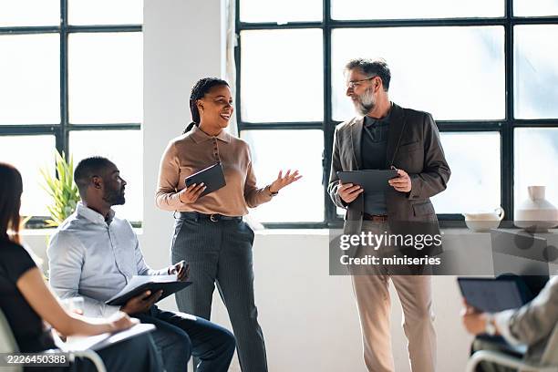 diverse team collaborating on a business project in a bright office setting - encouragement stock pictures, royalty-free photos & images
