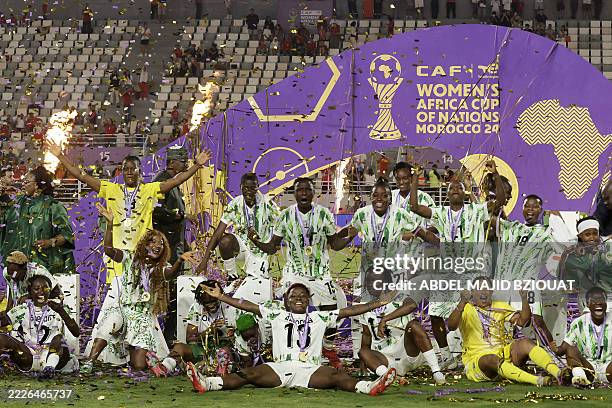 Nigeria's players celebrate with the trophy on the podium after winning the 2025 Women's Africa Cup of Nations final football match against Morocco...