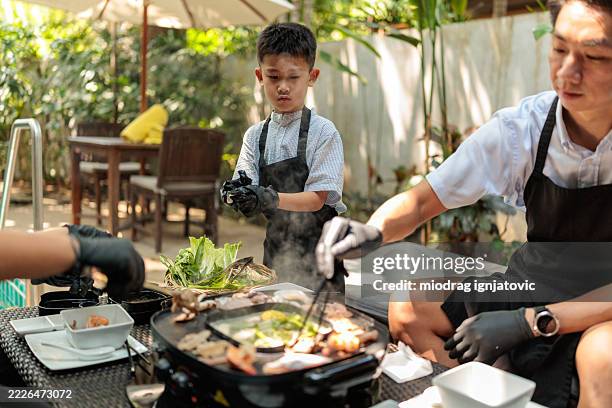 father and son preparing barbecue - staycation stock pictures, royalty-free photos & images