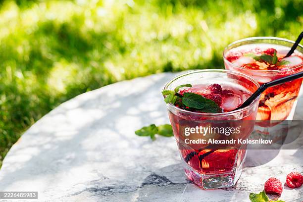 refreshing summer drink with raspberries and mint on a sunny day - raspberry cocktail stock pictures, royalty-free photos & images