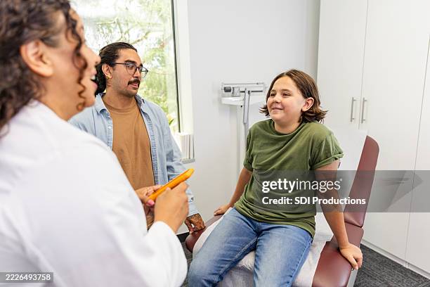 doctor talking with a child and parent in a medical clinic - endocrine system stock pictures, royalty-free photos & images