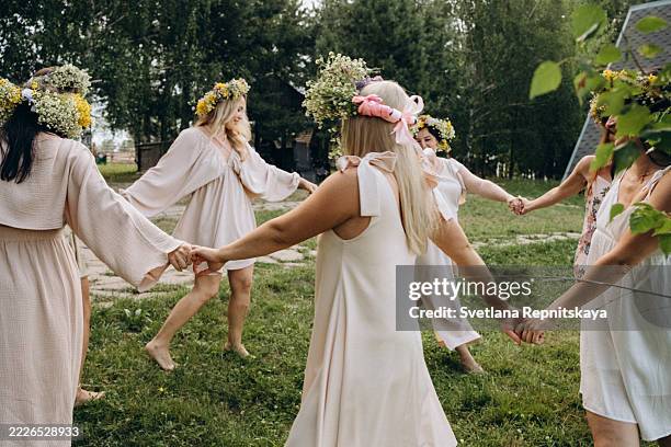 beautiful women holding hands and dancing in a circle outdoors - traditionelle kleidung stock-fotos und bilder