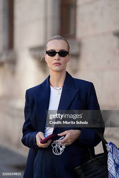 Marlies Pia Pfeifhofer is seen wearing a navy blue oversized double-breasted Biarritz blazer from Article Blazers; a white ribbed fitted Dena tank...