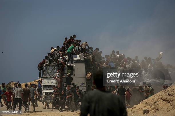 Palestinians walk for kilometers after receiving flour aid distributed from trucks that entered the Zikim area, a kibbutz in southern Israel, amid...