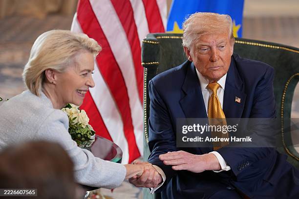 President Donald Trump and President of the European Commission Ursula von der Leyen shake hands as they announce a US-EU trade deal after a meeting...