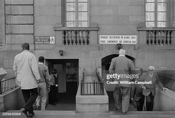 Separate toilets with signs reading ‘Non-European’ on one side and ‘Public Conveniences for European Men’ on the other, during the apartheid years in...