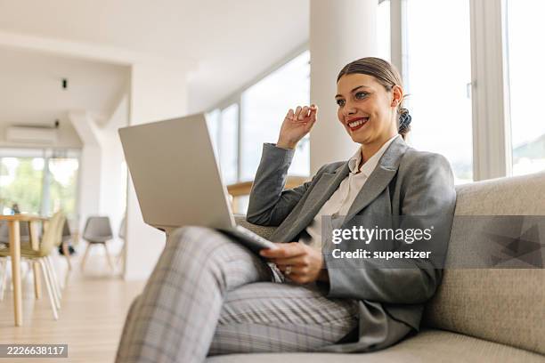 mujer concentrada con computadora portátil que muestra una profunda concentración - una sola mujer joven fotografías e imágenes de stock