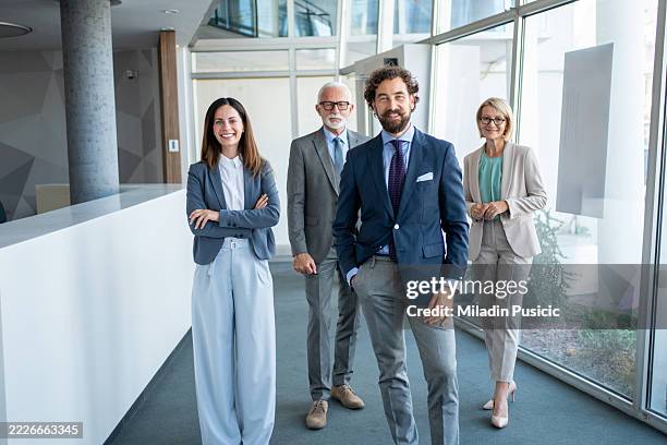 successful business team smiling together in modern office - four people stock pictures, royalty-free photos & images