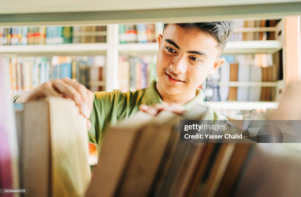 Asian student searching a book at a library