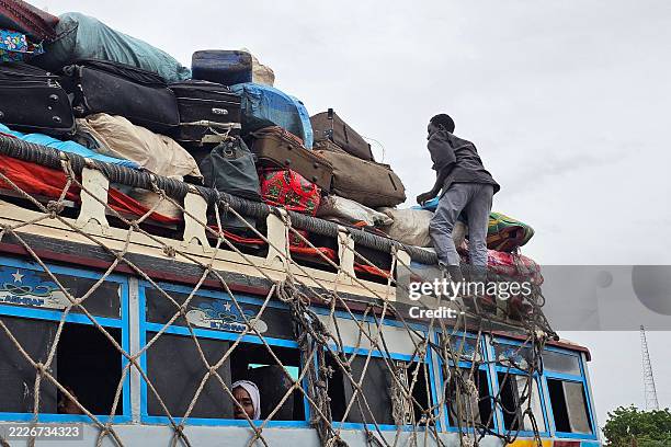 Displaced Sudanese arrive at a bus stop in Khartoum on July 28 upon their return to the capital.