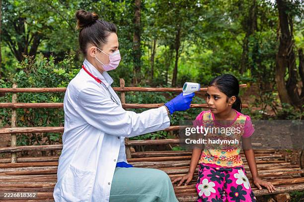 ärztin misst die körpertemperatur ihres patienten, sigiriya, ceylon - ärzte ohne grenzen stock-fotos und bilder