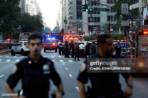 Police officers and emergency vehicles are seen in a street as police respond to a shooting incident in the Midtown Manhattan neighborhood of New...