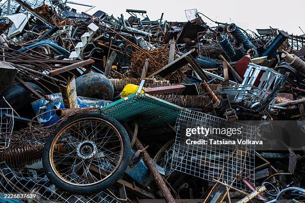 pile of rusty metal scrap including wheels and grid fencing pieces - circulaire economie stockfoto's en -beelden