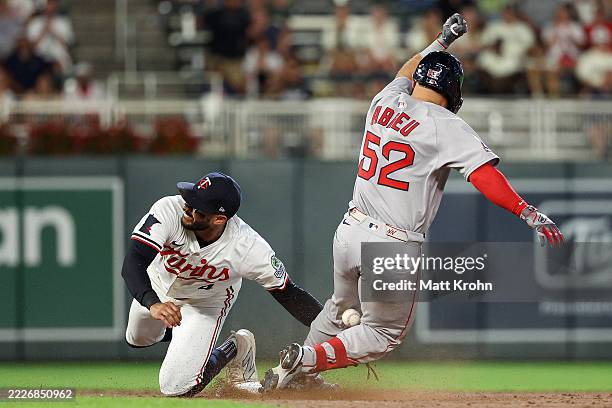 Wilyer Abreu of the Boston Red Sox slides safely into second base for a double as Carlos Correa of the Minnesota Twins attempts a tag during the...